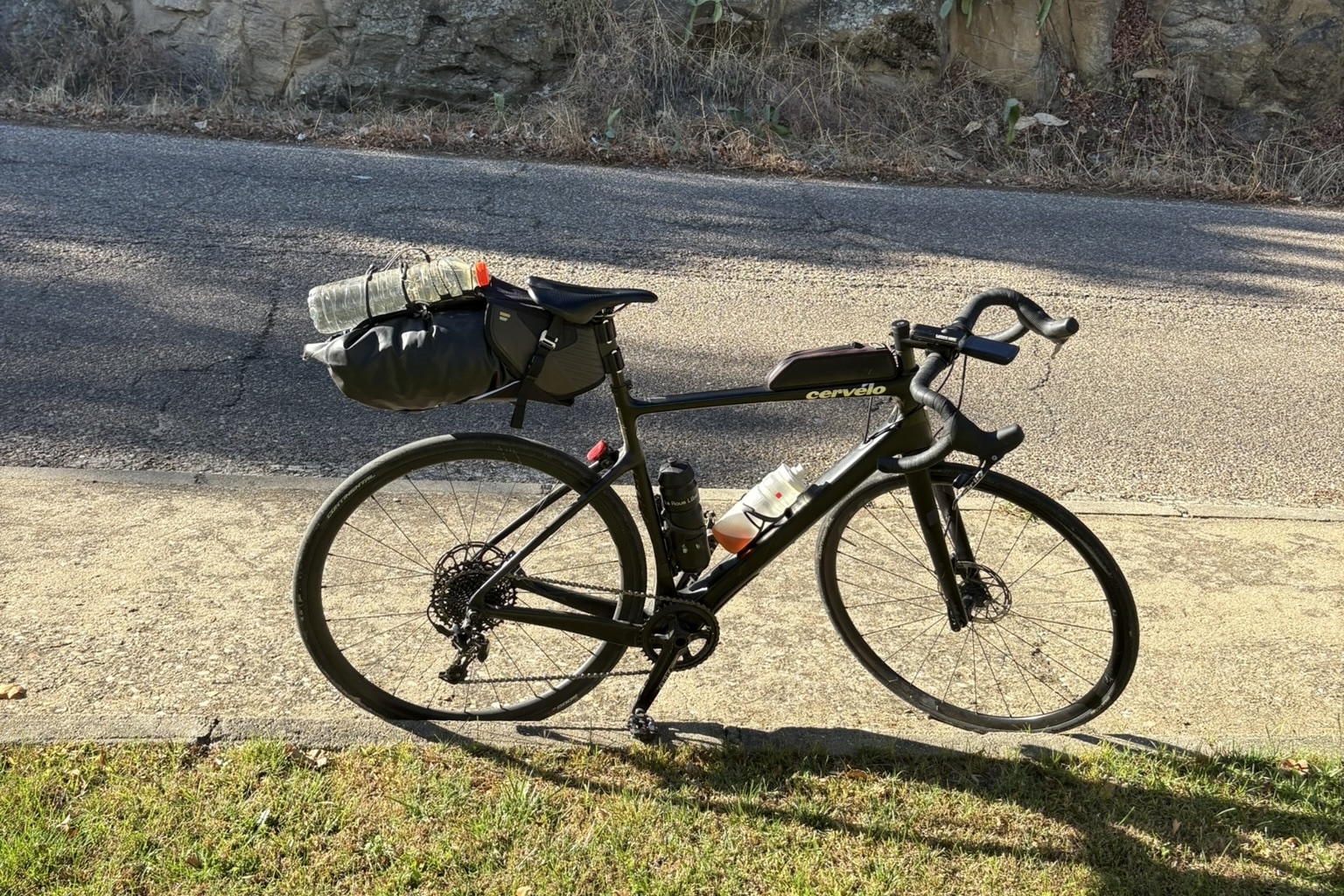 A road bike equipped with bikepacking bags, including a saddle bag, set up for a long-distance cycling trip.