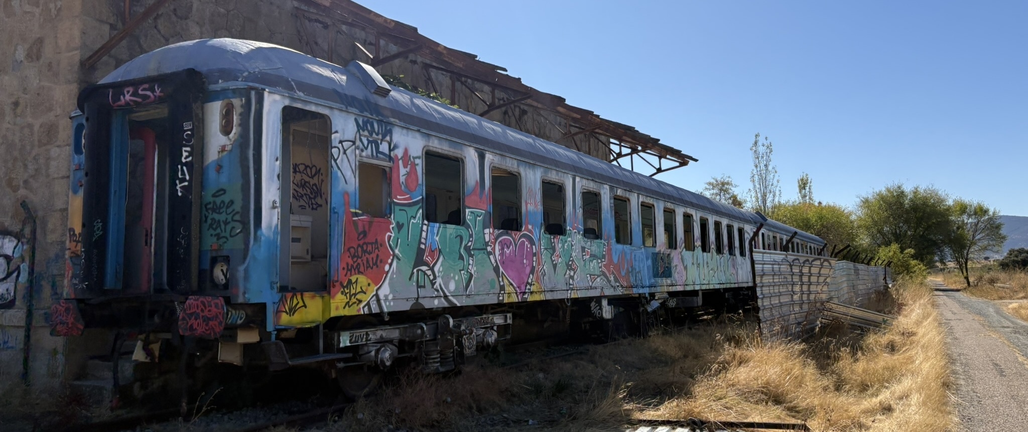 An abandoned train, covered in graffiti in one of the train stations along the Via Verde de la Jara.