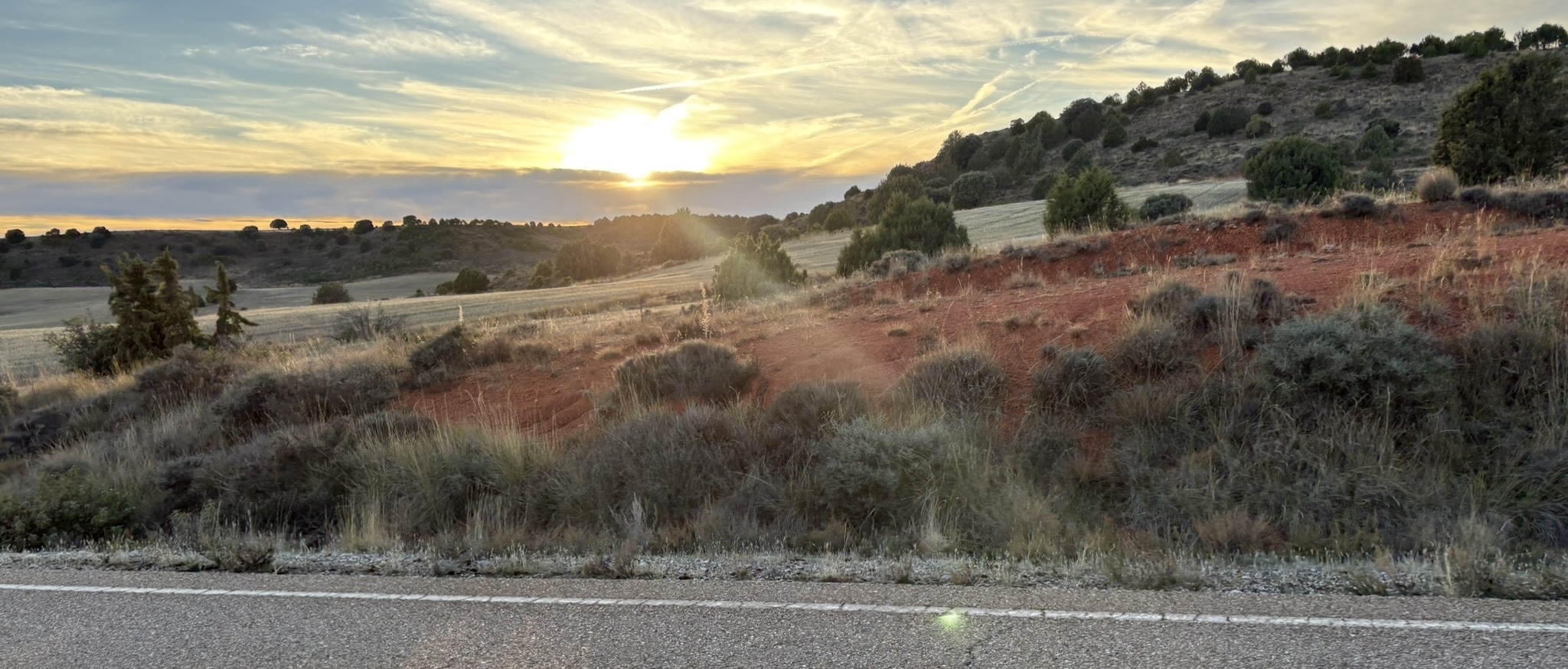 Sunset over the hills and mountains of the Sierra de la Demanda, with warm golden light illuminating the rolling terrain and valleys.